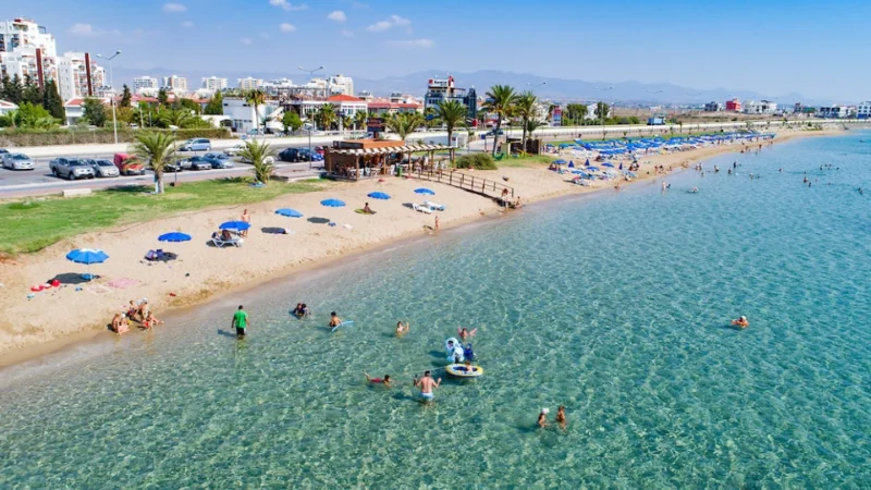 Sandy beach of Iskele North Cyprus, people enjoying the crystal clear water and the sunny atmosphere.