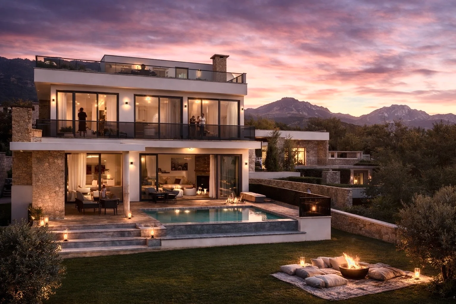 A high-end multi-story luxury villa in North Cyprus at sunset, featuring an infinity pool, outdoor lounge area, and a fire pit on a manicured lawn. The villa's large glass windows reflect a vibrant purple and orange sky, with the dramatic peaks of the Kyrenia Mountains in the background, illustrating premium investment potential.