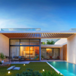 Villa exterior with a wooden pergola, grassy lawn, private pool, and glowing glass windows in Esentepe, North Cyprus.