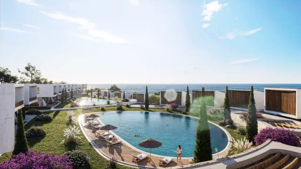 Pool area with sun loungers and umbrellas overlooking the Mediterranean Sea in North Cyprus.