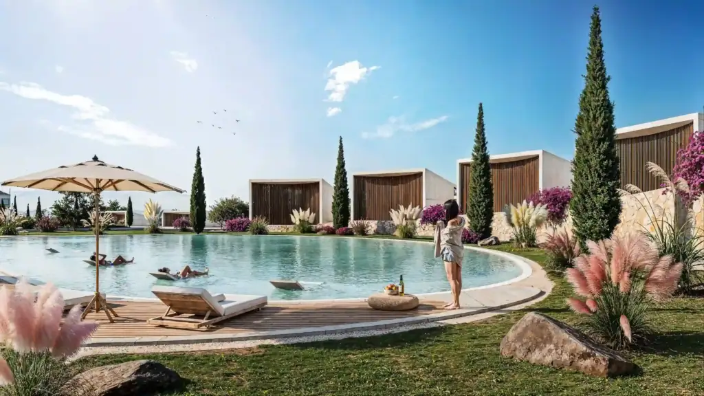 Elegant outdoor pool area with sun loungers, parasol, and lush landscaping in a North Cyprus property development.