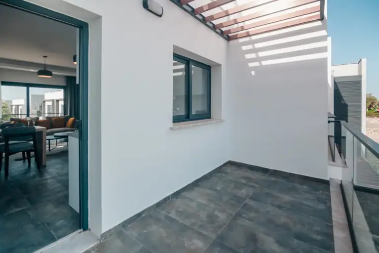 Balcony of a contemporary apartment with glass railing, overlooking the cityscape in North Cyprus. Perfect for relaxing outdo.
