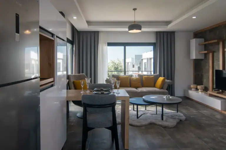 Bright and spacious living area featuring contemporary furniture and a large window with city views.