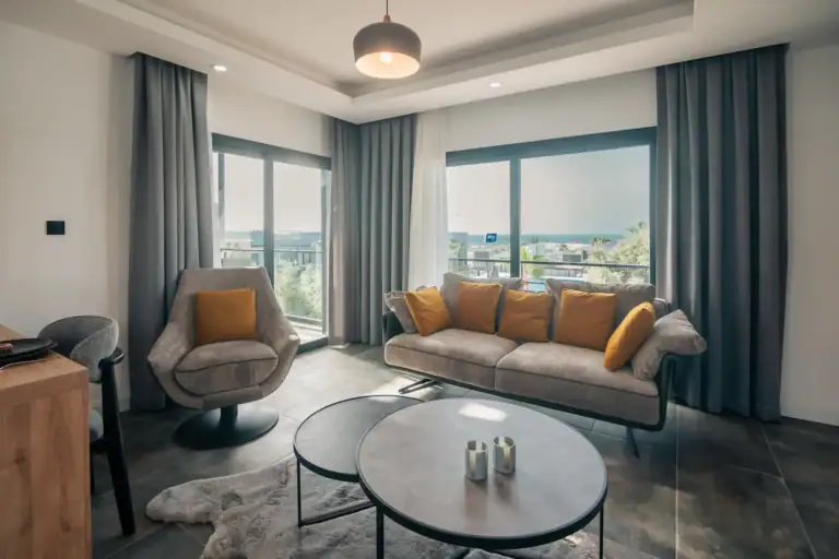 Spacious living area with large windows, contemporary furniture, and scenic views in North Cyprus.