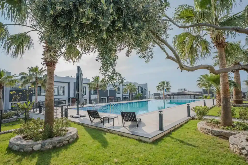 Luxury pool with sun loungers and palm trees at a North Cyprus development.