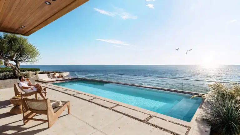 Seaside infinity pool overlooking the Mediterranean Sea with sun loungers and shaded seating area in North Cyprus.