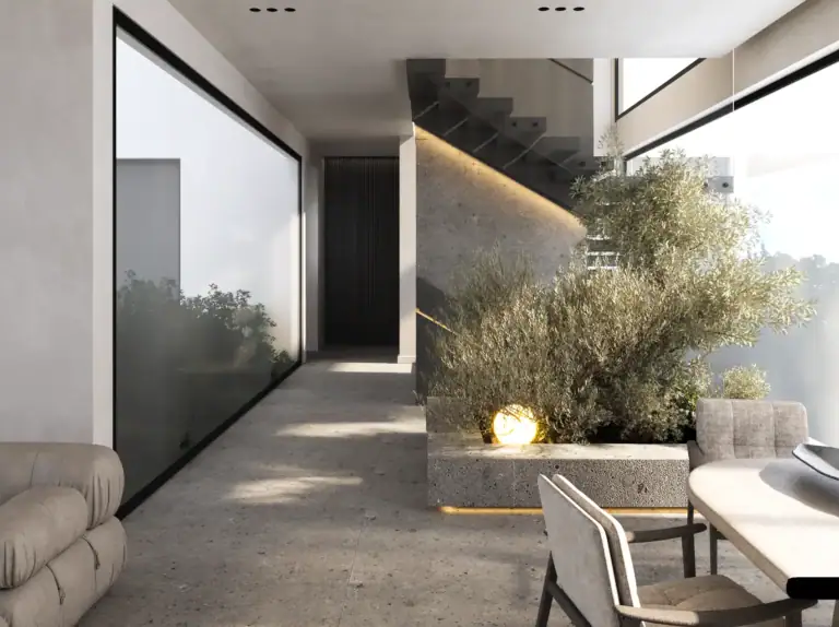 Modern minimalist foyer with concrete flooring, a floating staircase, a large built-in planter with lush greenery, and warm ambient lighting.