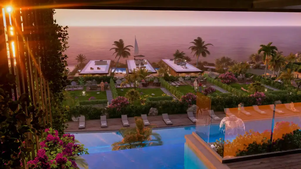 An elevated sunset view of a luxury resort featuring multiple pools, lush green gardens, palm trees, and the ocean.