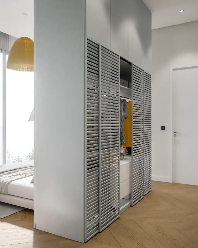 Built-in wardrobe with louvered doors in a modern bedroom interior.