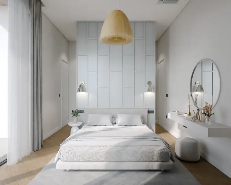 Bright, stylish bedroom with white walls, large mirror, and elegant furnishings.